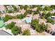 Aerial view of a desert community showcasing tile roofs, lush landscaping, and a community pool and cabana at 15151 N Frank Lloyd Wright Blvd # 1088, Scottsdale, AZ 85260