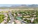 Aerial view of a desert community showcasing tile roofs, lush landscaping, a tennis court, and desert mountain views at 15151 N Frank Lloyd Wright Blvd # 1088, Scottsdale, AZ 85260