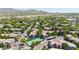 Aerial view of a desert community showcasing tile roofs, lush landscaping, a tennis court, and desert mountain views at 15151 N Frank Lloyd Wright Blvd # 1088, Scottsdale, AZ 85260