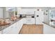 Bright kitchen featuring white cabinetry, granite countertops, wood-look flooring, and modern appliances at 15161 W Cactus Ridge Way, Surprise, AZ 85374