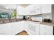 Bright kitchen features white cabinetry, granite countertops, stainless sink, and a view of the backyard at 15161 W Cactus Ridge Way, Surprise, AZ 85374