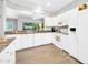 Bright kitchen features white cabinetry, granite countertops, stainless sink, and view into the living area at 15161 W Cactus Ridge Way, Surprise, AZ 85374