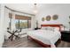 Bedroom with large window, wood floors, a glass desk, and an orange bed frame at 16734 E Gunsight Dr # 109, Fountain Hills, AZ 85268