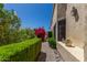 Charming walkway showcasing manicured hedges, bougainvillea and desert flora next to the home's exterior at 16734 E Gunsight Dr # 109, Fountain Hills, AZ 85268