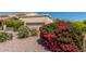 Beautiful home with lovely landscaping, including bougainvillea and desert plants, near the tan garage door at 16734 E Gunsight Dr # 109, Fountain Hills, AZ 85268