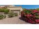 Beautiful home with lovely landscaping, including bougainvillea and desert plants, near the tan garage door at 16734 E Gunsight Dr # 109, Fountain Hills, AZ 85268