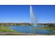 Picturesque view of lake fountain set against lush green grass and distant mountains under a clear blue sky at 16734 E Gunsight Dr # 109, Fountain Hills, AZ 85268