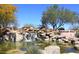 Picturesque Fountain Hills entrance featuring a waterfall cascading into a tranquil pond surrounded by desert landscaping at 16734 E Gunsight Dr # 109, Fountain Hills, AZ 85268