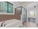 Bathroom featuring a soaking tub, large glass shower, and view into the bedroom at 1824 N Red Clf, Mesa, AZ 85207