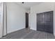 Neutrally decorated bedroom with dark closet doors and trim, offering a serene and uncluttered space at 1824 N Red Clf, Mesa, AZ 85207
