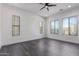 Spacious bedroom with many windows for natural light, a ceiling fan, and sleek, gray tile flooring at 1824 N Red Clf, Mesa, AZ 85207