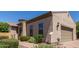Exterior of a tan home with well-kept landscaping and brick paver driveway at 1824 N Red Clf, Mesa, AZ 85207