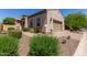 Charming home featuring desert landscaping, brick accents, and a tan stucco exterior at 1824 N Red Clf, Mesa, AZ 85207