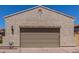 View of the home's garage featuring tan stucco and a paver driveway at 1824 N Red Clf, Mesa, AZ 85207