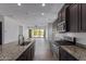 Modern kitchen featuring stainless appliances, granite counters, dark wood cabinets, and outdoor access at 1824 N Red Clf, Mesa, AZ 85207