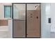Close up of large glass-enclosed shower with bronze hardware at 1824 N Red Clf, Mesa, AZ 85207
