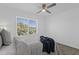 Cozy bedroom with a plush bed, ceiling fan, and a large window offering great views and natural light at 19601 N 7Th St # 2095, Phoenix, AZ 85024