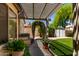 A charming backyard features a covered patio, pergola, archway, and lush green synthetic grass at 2244 E Rawhide St, Gilbert, AZ 85296