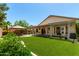 This backyard features a covered patio, pergola, synthetic lawn, and gazebo with outdoor furniture at 2244 E Rawhide St, Gilbert, AZ 85296