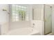 Bright bathroom showcasing a glass block window, soaking tub, and glass enclosed shower for added comfort at 2244 E Rawhide St, Gilbert, AZ 85296