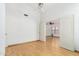 Open bedroom with light wood floors, white walls, ceiling fan, and a doorway leading to another room at 2244 E Rawhide St, Gilbert, AZ 85296