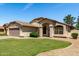 Well-maintained single-story home with green lawn, desert landscaping, and a two-car garage at 2244 E Rawhide St, Gilbert, AZ 85296