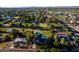 This aerial view captures the home's generous lot, lush greenery, mature trees, and a private tennis court at 2350 E Melrose St, Gilbert, AZ 85297