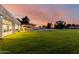 Expansive green backyard featuring lush lawn, a tennis court and covered patio at 2350 E Melrose St, Gilbert, AZ 85297