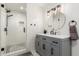 This updated bathroom features a tile shower and vanity area with matte black fixtures and contemporary lighting at 2350 E Melrose St, Gilbert, AZ 85297