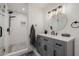 Bathroom featuring a gray vanity with double sinks, a round mirror, and a walk-in shower at 2350 E Melrose St, Gilbert, AZ 85297