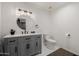 Elegant bathroom featuring a gray vanity, quartz countertop, modern fixtures, and a round mirror at 2350 E Melrose St, Gilbert, AZ 85297