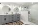 This renovated bathroom boasts double sinks with sleek gray cabinetry and a spacious glass-enclosed tiled shower at 2350 E Melrose St, Gilbert, AZ 85297