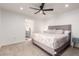 This bright bedroom offers a ceiling fan, neutral carpeting, and an ensuite bathroom at 2350 E Melrose St, Gilbert, AZ 85297