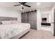 Bedroom with barn door closet, ceiling fan, and neutral carpeting for comfort and modern convenience at 2350 E Melrose St, Gilbert, AZ 85297