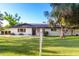 Charming single-story home featuring a lush green lawn and mature trees under a clear blue sky at 2350 E Melrose St, Gilbert, AZ 85297