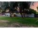 Single-story home features a lush green lawn with mature trees in the front yard, offering shade and curb appeal at 2350 E Melrose St, Gilbert, AZ 85297