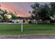 Charming single-story home featuring a lush green lawn and mature trees under a colorful sunset sky at 2350 E Melrose St, Gilbert, AZ 85297