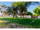 Single-story home features a lush green lawn with mature trees in the front yard, offering shade and curb appeal at 2350 E Melrose St, Gilbert, AZ 85297