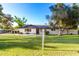Charming single-story home featuring a lush green lawn and mature trees under a clear blue sky at 2350 E Melrose St, Gilbert, AZ 85297