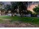 Single-story home features a lush green lawn with mature trees in the front yard, offering shade and curb appeal at 2350 E Melrose St, Gilbert, AZ 85297
