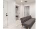 Hallway with marble-look tile, a grey futon, and doors to various rooms, creating a seamless transition between spaces at 2350 E Melrose St, Gilbert, AZ 85297