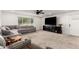 Bright living room featuring plush gray sectional sofa, neutral carpet, and large window at 2350 E Melrose St, Gilbert, AZ 85297