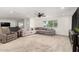 Spacious living room boasts plush gray sectional, recliner, and natural light from large window at 2350 E Melrose St, Gilbert, AZ 85297