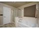 Bathroom featuring soaking tub, glass shower, and neutral tile at 26062 W Potter Dr, Buckeye, AZ 85396