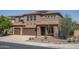 Charming two-story home with a three car garage and desert landscaping with solar panels on the roof at 26062 W Potter Dr, Buckeye, AZ 85396