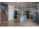 Open kitchen with gray cabinetry, center island, and staircase at 26062 W Potter Dr, Buckeye, AZ 85396