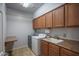Functional laundry room features cabinetry, sink, washer, and dryer hookups and a folding table at 26062 W Potter Dr, Buckeye, AZ 85396
