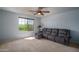 Comfortable living room featuring a plush gray sectional couch and a ceiling fan at 26062 W Potter Dr, Buckeye, AZ 85396