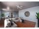 Living room with ceiling fan, large sectional sofa and home office space at 26062 W Potter Dr, Buckeye, AZ 85396