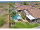 Aerial view of a backyard oasis with a pool, mature landscaping, covered patio, and green grass at 26624 N 41St St, Cave Creek, AZ 85331